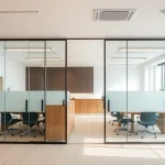Showcasing movable glass partitions enhancing space aesthetics and functionality in a modern office environment.